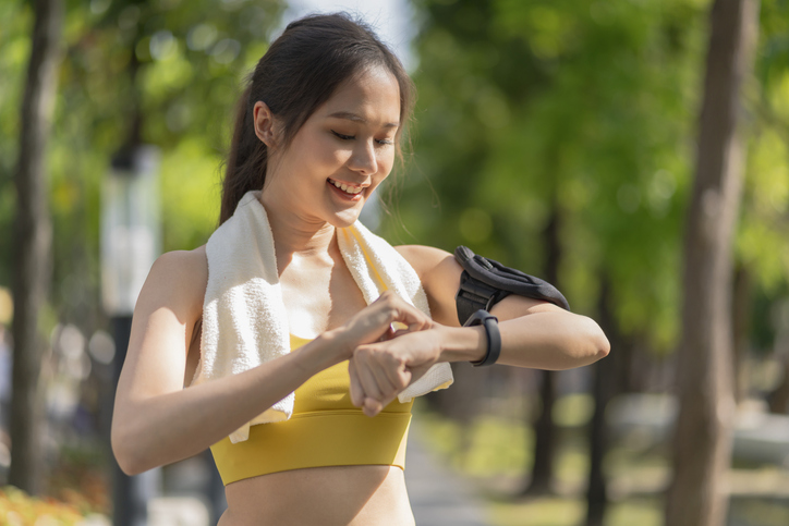 asian Fitness woman setting up smart watch before running training during morning workoutfemale checking heartrate and pulse from smart watch monitor after running fininsh healthy lifestyle concept